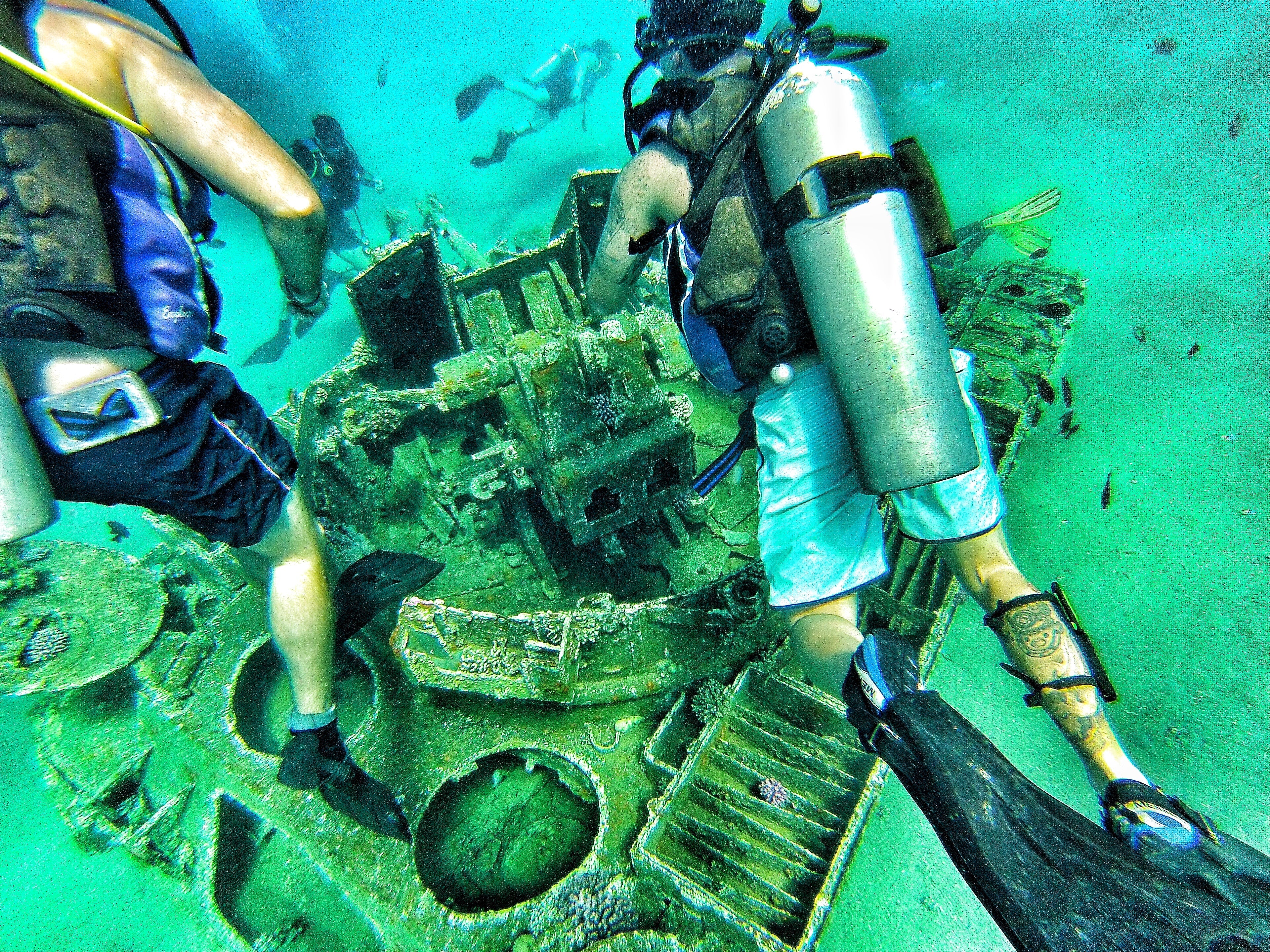 A group of divers investigating sunken equipment underwater