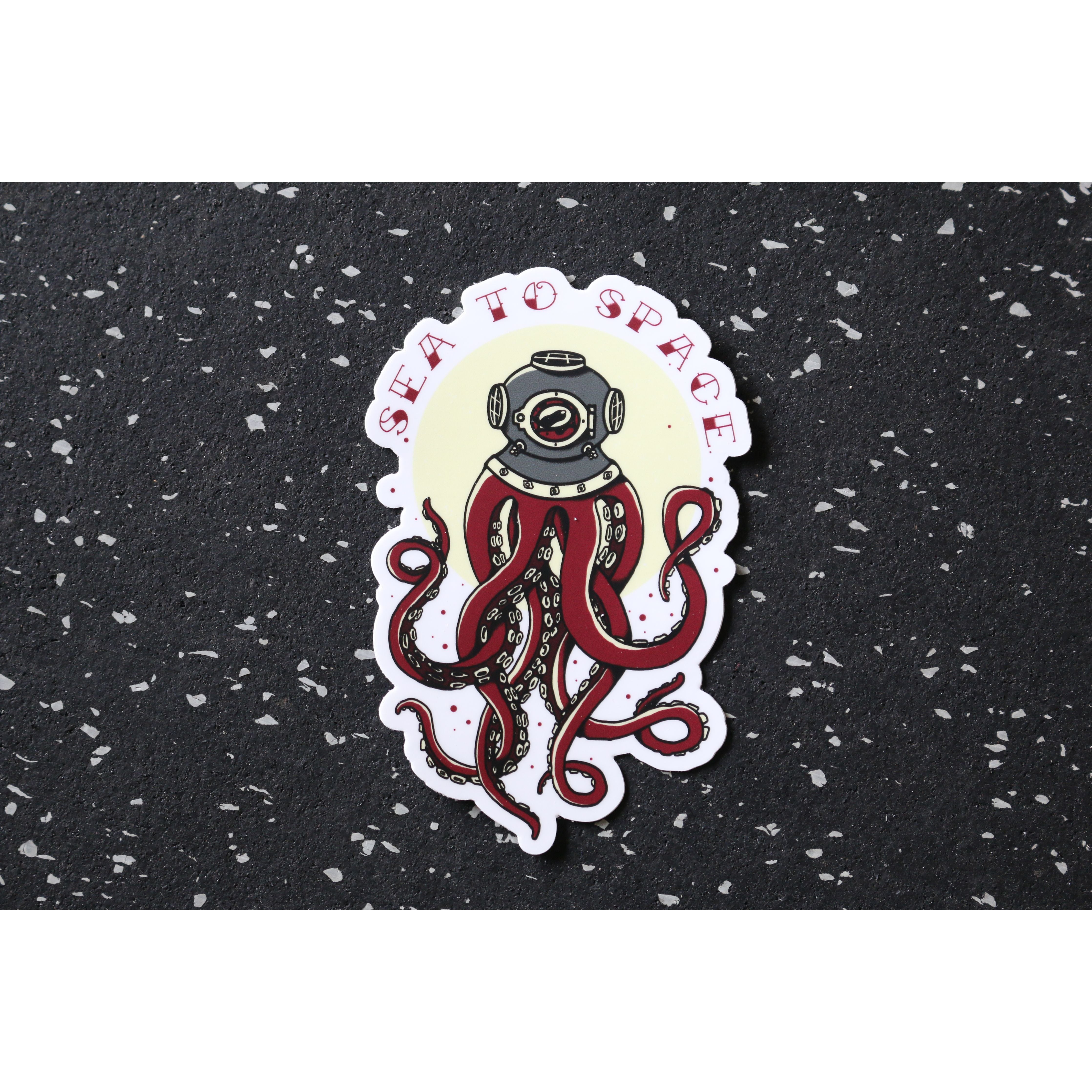 Sea to Space Sticker – sticker of dive helmet with tentacles and “Sea to Space” text above on a spotted black background