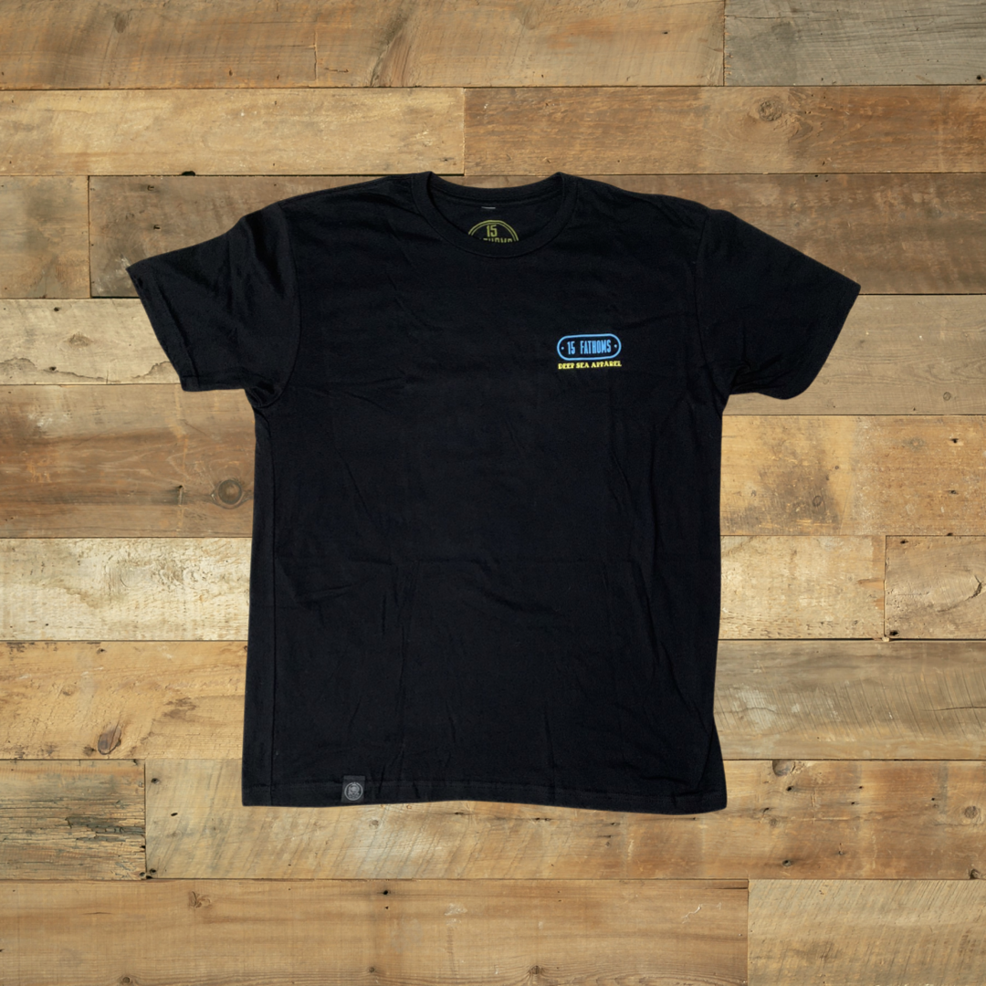 Kraken - black t-shirt with "15 Fathoms Deep Sea Apparel" text over the heart on front over wooden background