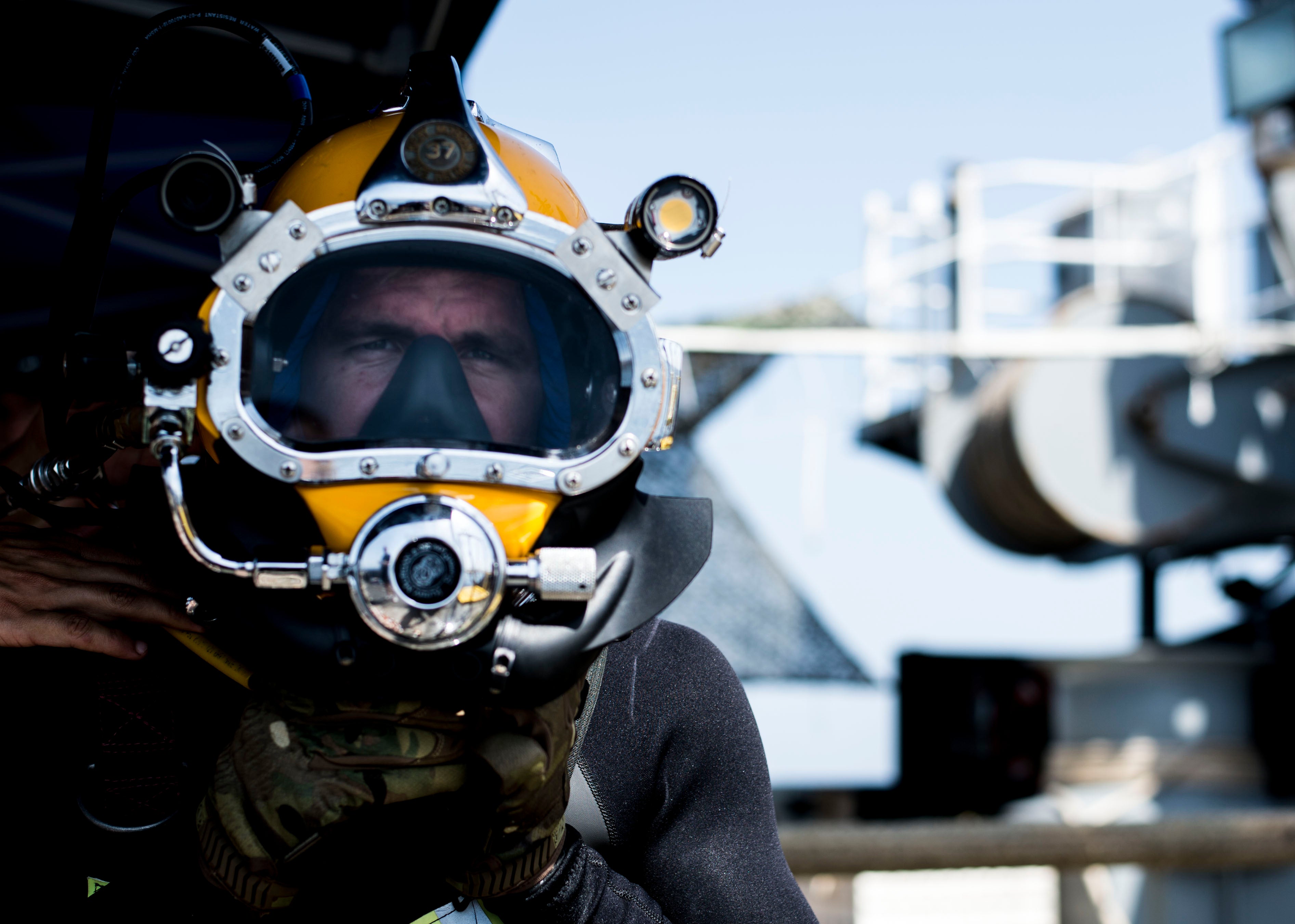 Man wearing a large diving helmet with a looking straight into the camera
