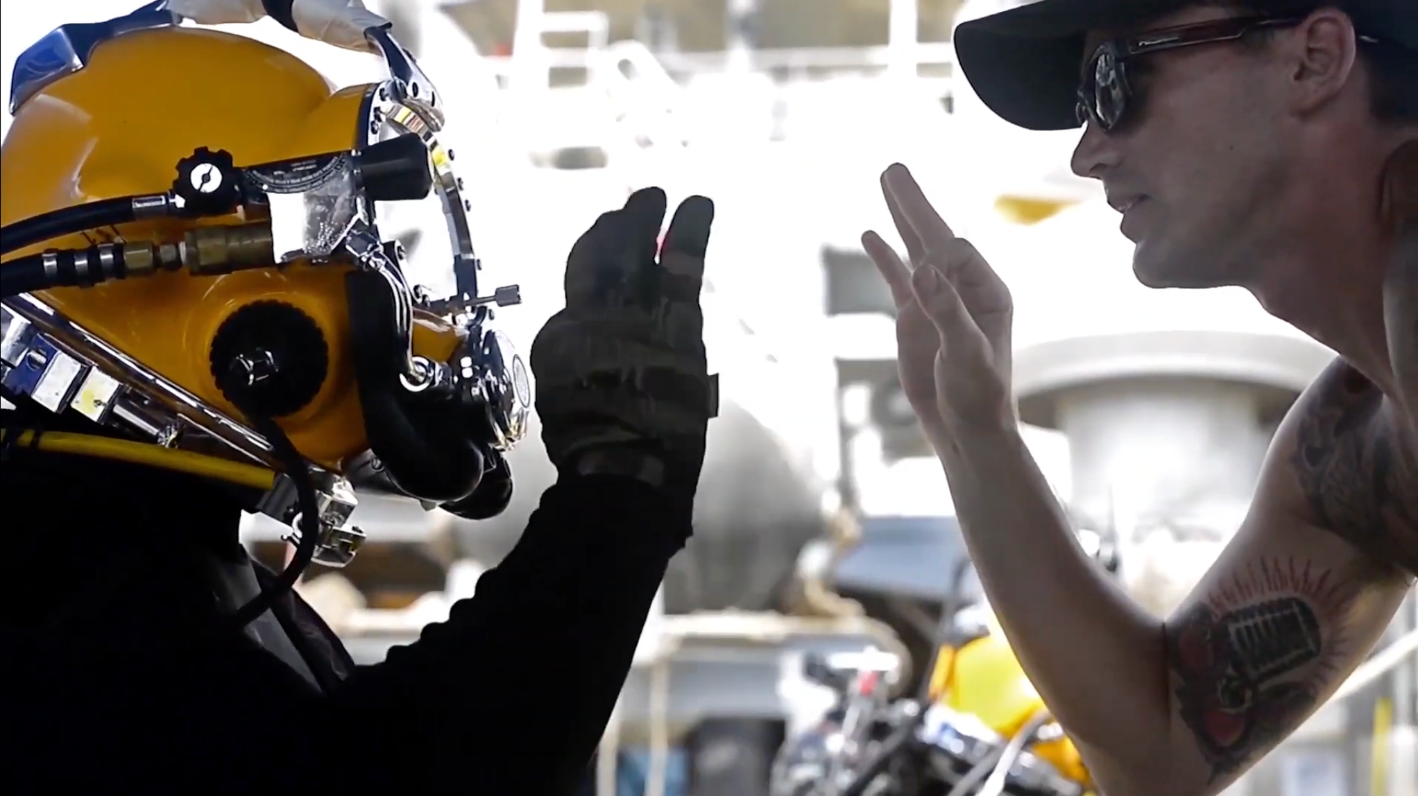 A diver and a crew member giving each other the O K signal in preparation for a diving mission