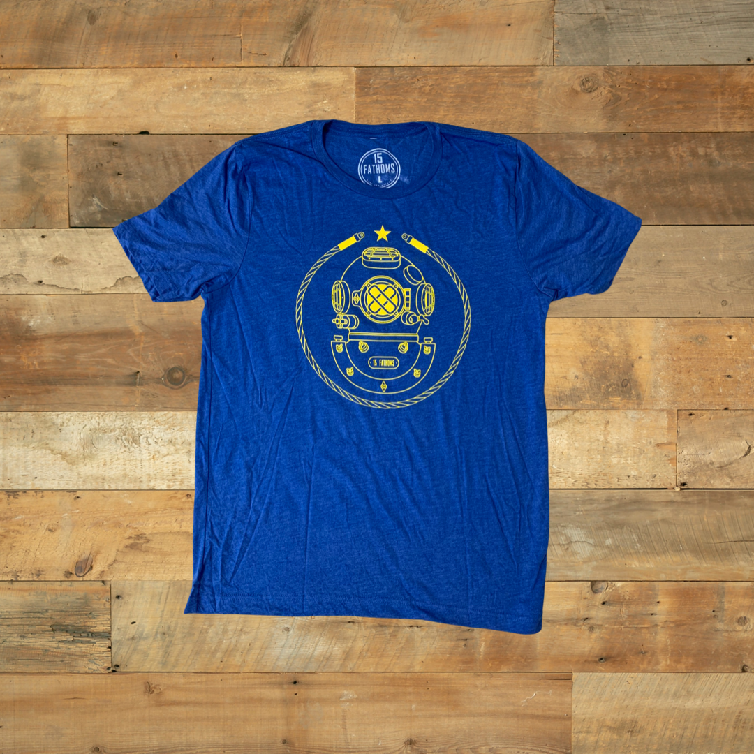 Project Aware Iconic - blue t-shirt with gold diver helmet logo on front on wooden background